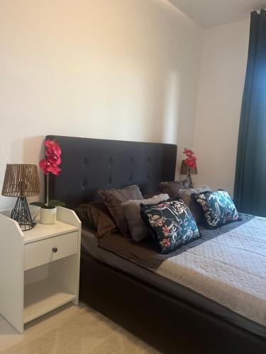 a bed with a black headboard and pillows on it at SeaViev Torrevieja in Torrevieja