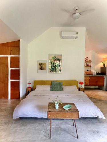 a bedroom with a large bed and a wooden table at PaChaSi Samui Bungalows in Ban Bang Po
