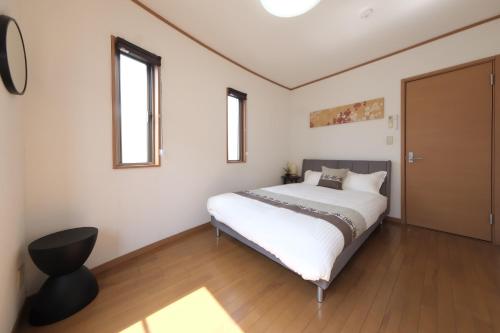 a bedroom with a large white bed and two windows at Villa Lotus in Kamakura