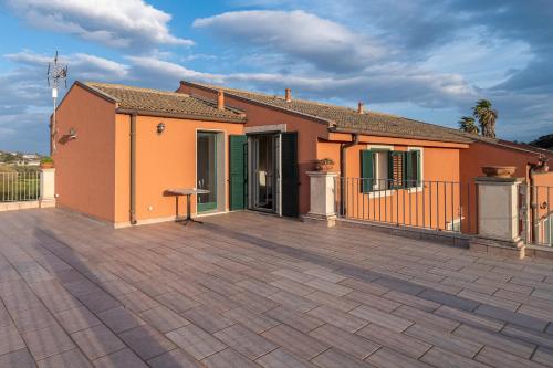 a house with a large patio in front of it at Al Palmento Relais in Siracusa