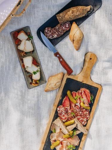 a table with a plate of food with meat and vegetables at Hotel Corsica & Spa Serena in Calvi