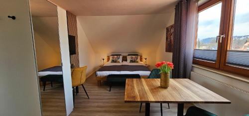 una stanza con un letto e un tavolo con dei fiori sopra di Elodia Luxus Apartment - WLAN, Magenta TV, Terrasse, Küche, Babybett a Heidenheim an der Brenz