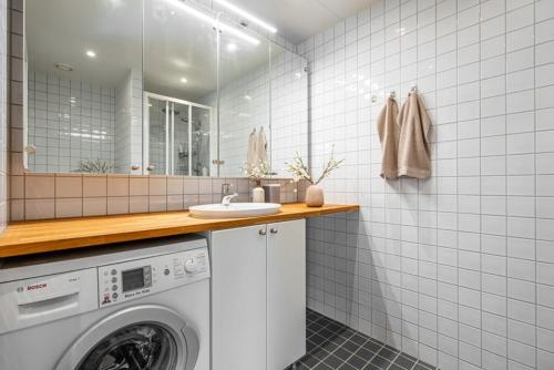 a bathroom with a washing machine and a mirror at PP1b-Central-Cosy studio flat Suits globetrotters in Oslo