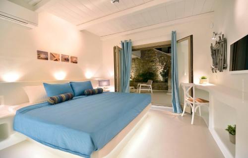 a bedroom with a blue bed and a balcony at Villa Castalia by Thalassa Residence Mykonos in Elia Beach