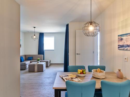 a dining room and living room with a table and chairs at Holiday Suites Zeebrugge in Zeebrugge