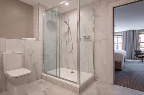 a bathroom with a shower with a toilet and a sink at Coachmans Townhouse Hotel in Kenmare