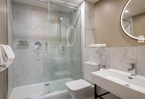 a bathroom with a shower and a toilet and a sink at Coachmans Townhouse Hotel in Kenmare
