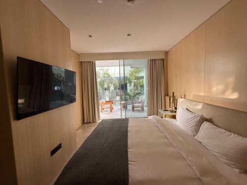 迪拜Palm Haven Luxe 3 Bed Townhouse with Private Pool的酒店客房,设有床铺和墙上的电视