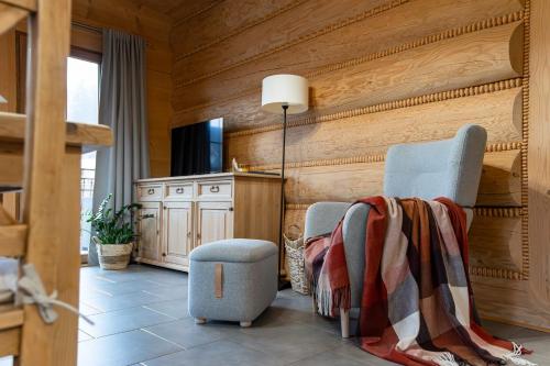 a living room with two chairs and a table at Apartamenty Augustynówka in Brzegi