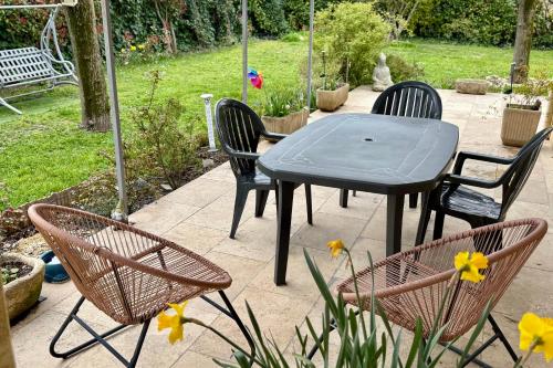 une table, quatre chaises, une table et des fleurs dans l'établissement Air-Conditioned House with Private Garden in Le Thor pets are welcome, au Thor