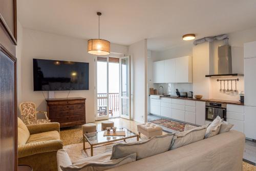 a living room with a couch and a kitchen at Bright and scenic flat 7km from Bellagio downtown in Civenna