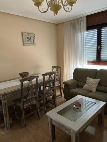 a living room with a table and a couch at Apartamentos Costa Noja in Noja