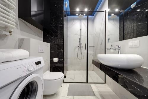 a bathroom with a washing machine and a sink at Urban Chic - Sokolska 30 Towers -Studio Apartment - S74 in Katowice