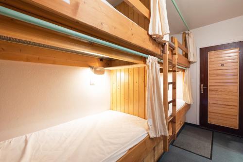 two bunk beds in a room with a door at Gourette - Au pieds des pistes in Eaux-Bonnes