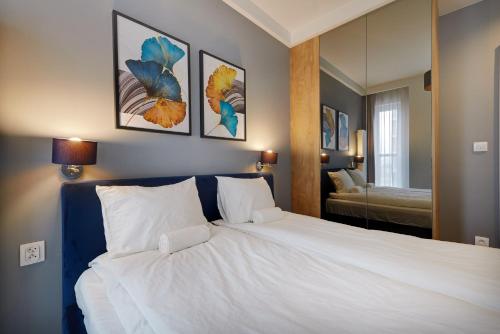 a bedroom with a large white bed with a mirror at Central Apartments Katowice - City Center - Chic and Luxury - S59 in Katowice