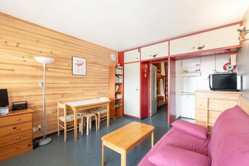 un salon avec un canapé violet et une table dans l'établissement Gourette - Au pieds des pistes, à Eaux-Bonnes