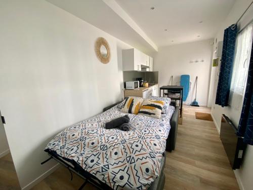 une chambre avec un lit sur lequel est allongé un chat dans l'établissement Nid Cosy au Centre de Rouen - 074, à Rouen