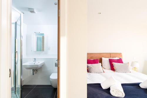 a bathroom with a bed and a toilet and a sink at Mayfleet HM19 Lower Mill Estate Cotswolds in Somerford Keynes