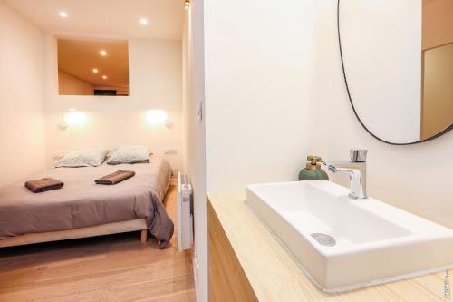 bagno con lavandino e letto con specchio di L'appartement du centre - Hypercentre - Lavaur a Lavaur