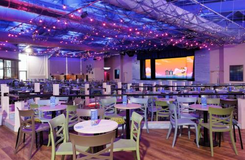 a dining room with tables and chairs and purple lights at Haven Holiday Home at Kent Coast Allhallows in Allhallows