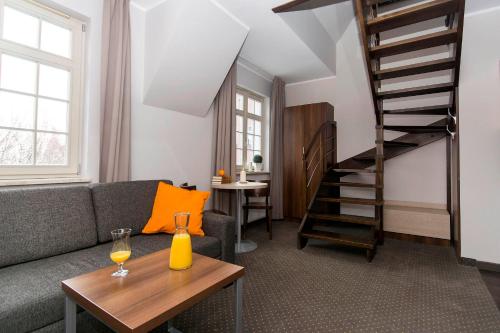a living room with a couch and a stair case at Apart Neptun in Gdańsk