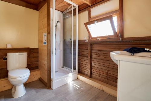 a bathroom with a toilet and a shower and a sink at Camping Au Soir D'été in Mesquer