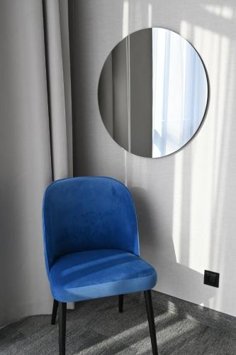a blue chair in front of a mirror at Hotel Centrum Malbork in Malbork