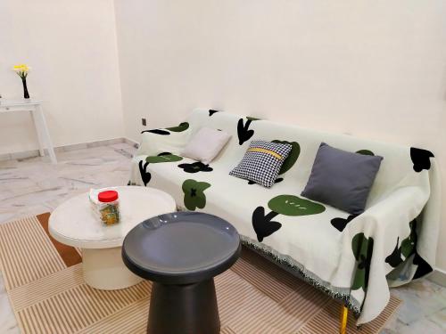 a couch with pillows and a table in a room at Mootopia BM homestay room rent in Bukit Mertajam