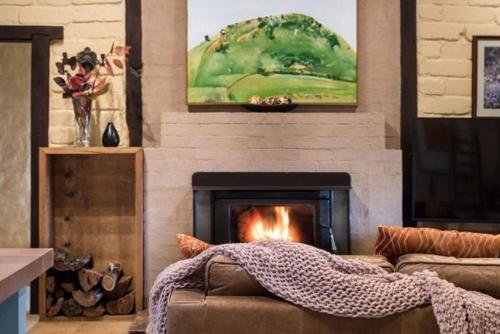 a living room with a couch and a fireplace at Italian Hill Garden Villa in Daylesford