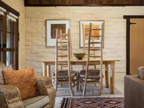 a dining room with a wooden table and chairs at Italian Hill Garden Villa in Daylesford