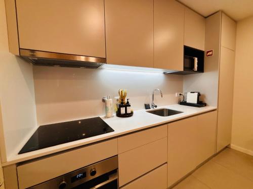a kitchen with a sink and a counter top at Modern apartment with balcony and free parking in Porto