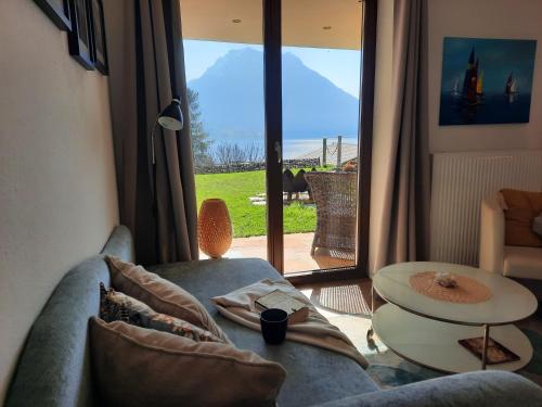 una sala de estar con un sofá y una mesa en Inspiration - zwei Terrassen mit Seeblick und Garten, en Altmünster