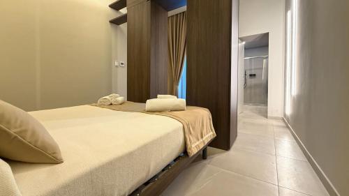 a bedroom with a bed with towels on it at Shanti Rooms & Apartments Castello in Bacoli