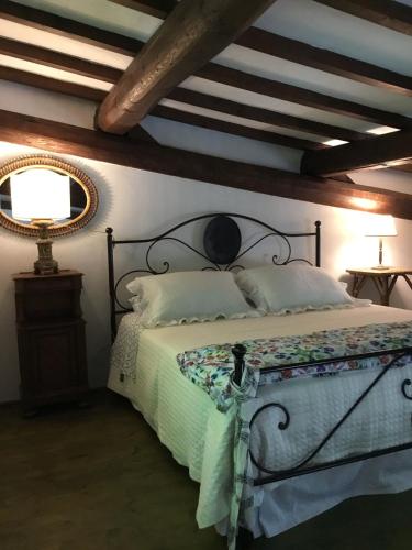 a bedroom with a bed and a ceiling with beams at Chalet fronte piscina in Zambra