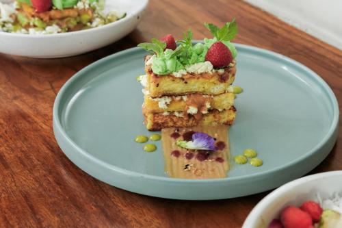 a plate with a piece of cake with strawberries on it at Sampatti Villas in Seminyak
