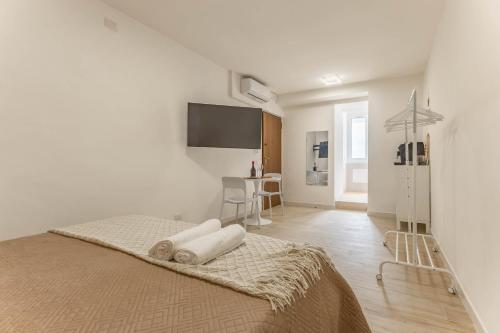 a white bedroom with a bed with towels on it at 4 Twins - Central Room in Bari
