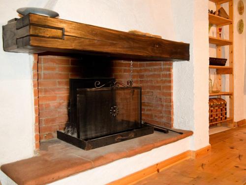 a brick fireplace in a room with a wooden mantle at B&B Levigliani in Levigliani