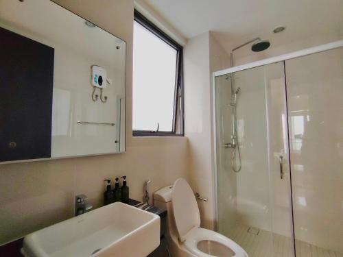 a bathroom with a toilet and a sink and a shower at Ocean View Family Suite in Johor Bahru