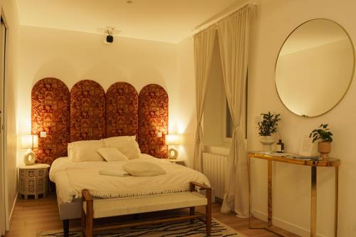 une chambre avec un grand lit avec un grand miroir dans l'établissement Suite Meraki - Luxe & Voyage - Jacuzzi & Cinéma, à Saint-Étienne