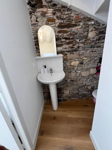 une salle de bain avec un lavabo et un mur en pierre dans l'établissement STUDIO CENTRE VILLE ANGERS RDC - 2 personnes, à Angers