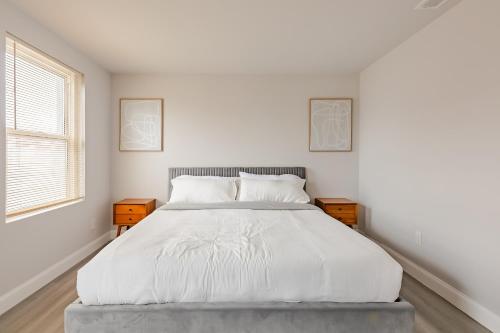 a white bedroom with a large bed with two night stands at Philly Getaway - Chic Stay Near Center City in Philadelphia