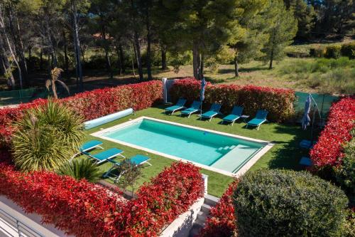 - une piscine dans un jardin avec des chaises et des fleurs dans l'établissement New villa in Le Castellet with pool Superb view Villa neuve au Castellet avec piscine et superbe vue, au Castellet