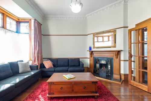 a living room with a couch and a fireplace at Stylish Victorian Home Near Walk to Beach & Te Papa in Wellington