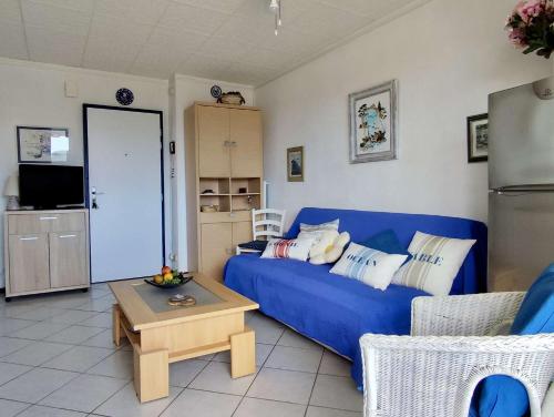 un salon avec un canapé bleu et une table dans l'établissement Appartement T2 - 4 couchages - ARGELES SUR MER AR850-173, à Argelès-sur-Mer