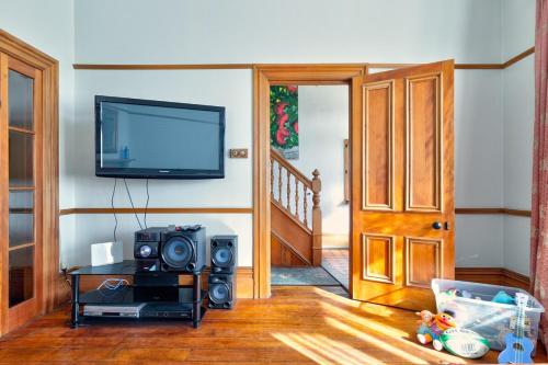 a living room with a tv and a speaker at Stylish Victorian Home Near Walk to Beach & Te Papa in Wellington