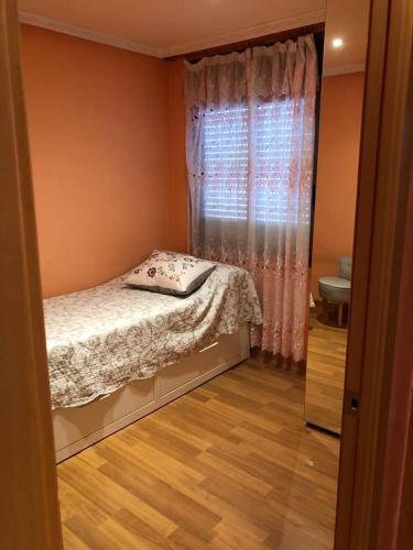 a small bedroom with a bed and a window at Bonito piso de 4 habitaciones- Port Aventura in Vila-seca