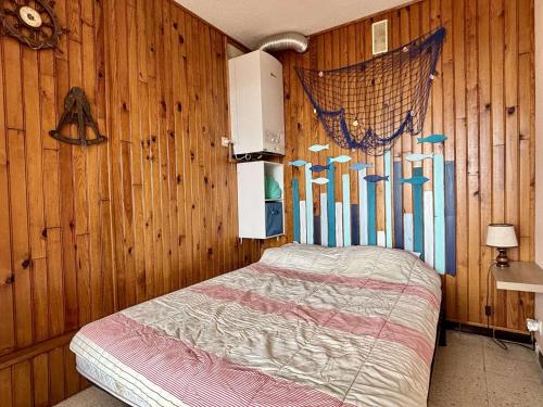 une chambre avec un lit dans un mur en bois dans l'établissement Appartement 2 pièces - 4 couchages - ARGELES SUR MER AR200-086, à Argelès-sur-Mer