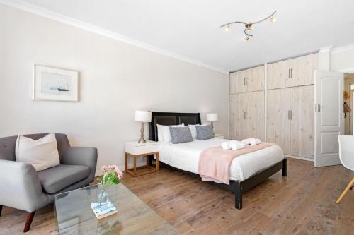 a bedroom with a bed and a couch and a chair at Blouberg Heights 1608 by Host Agents in Bloubergstrand