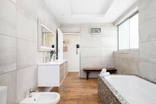 a bathroom with a tub and a sink and a toilet at Blouberg Heights 1608 by Host Agents in Bloubergstrand