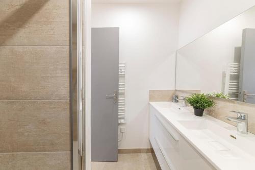 une salle de bain blanche avec deux lavabos et une douche dans l'établissement LE TOPAZE Wifi Patio Centre-ville, à Angers